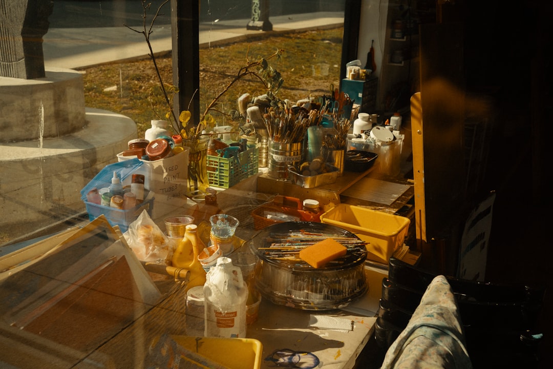 Artist's cluttered workspace with brushes and paints.