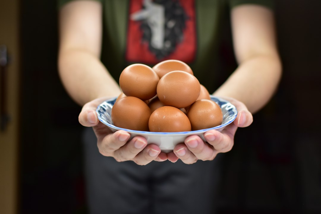person holding brown egg shell