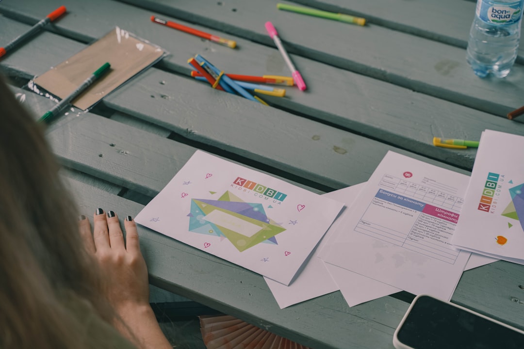 Colorful markers and papers on a wooden table