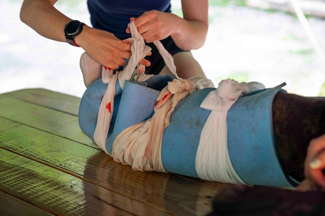 Applying a splint to an injured leg with bandages.