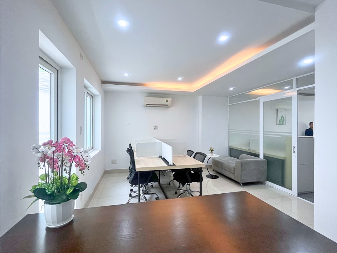 Modern office space with desks, chairs, and sofa.