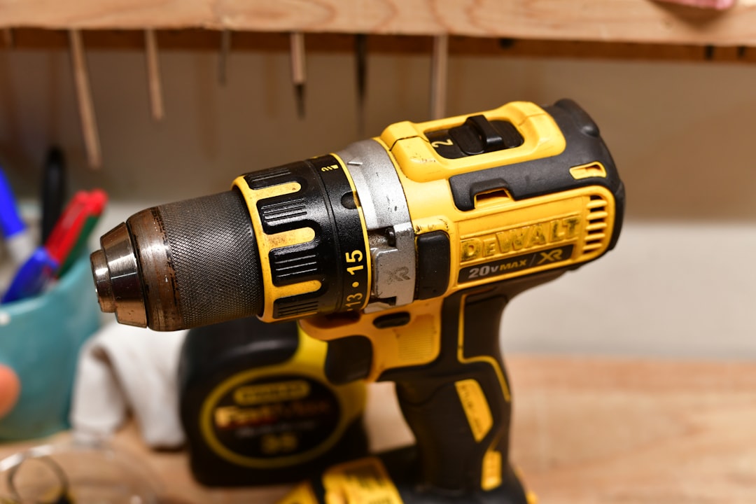 Yellow and black cordless power drill on a workbench.