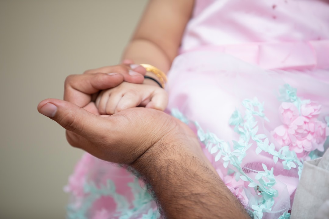 a close up of a person holding a baby's hand