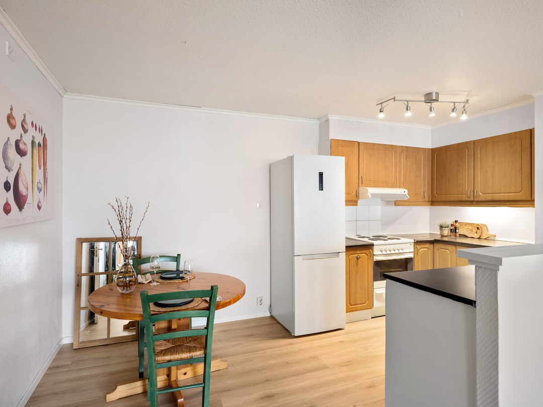 A kitchen with a table and chairs and a refrigerator