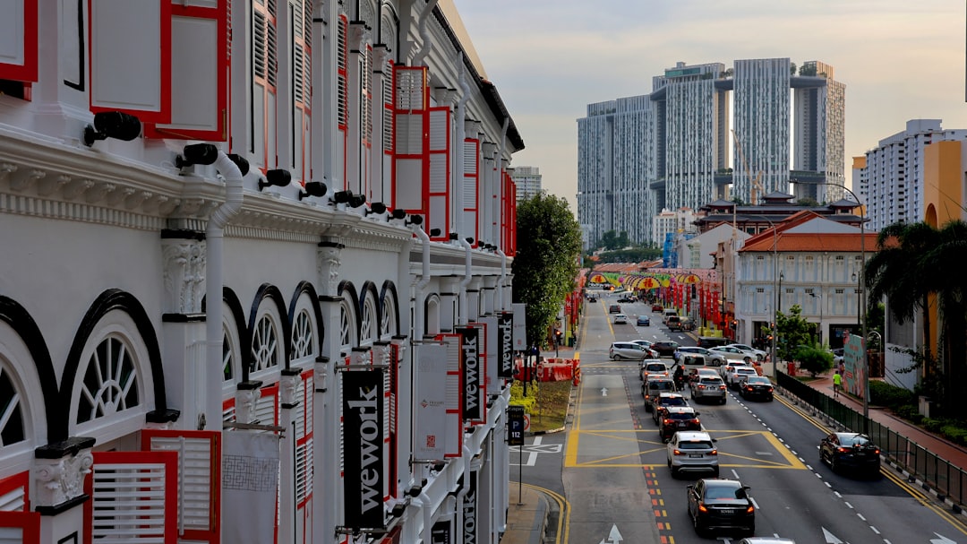 a city street filled with lots of traffic next to tall buildings
