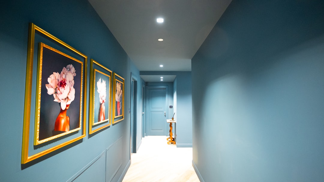 Hallway with blue walls and framed floral artwork.
