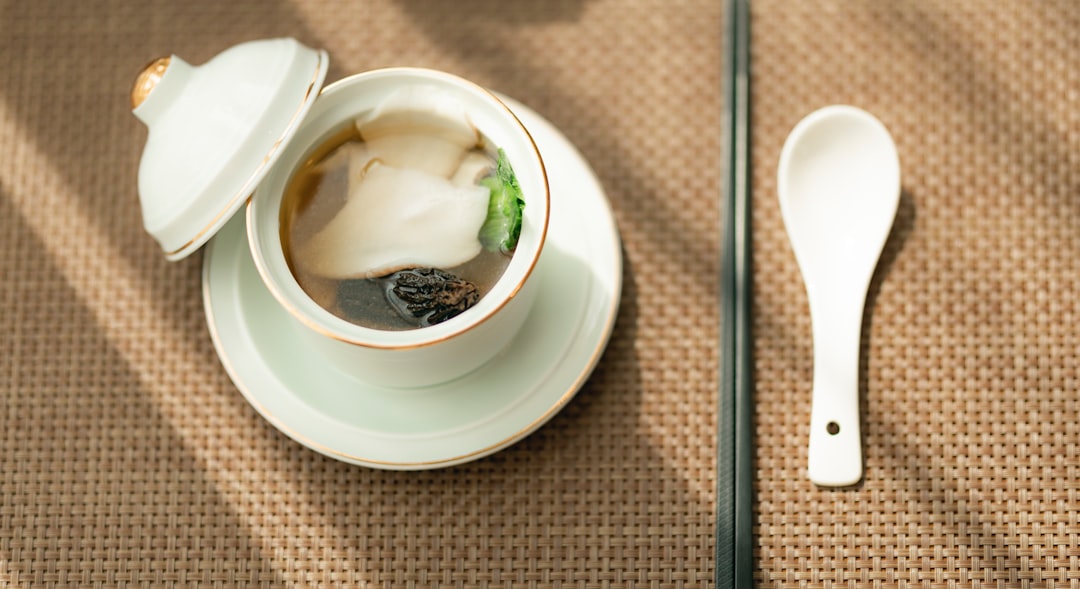 white ceramic bowl with stainless steel spoon on white ceramic plate