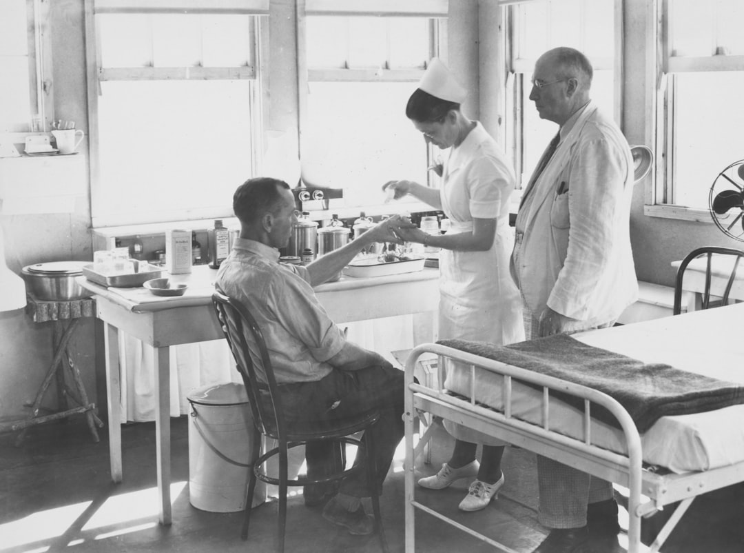 Nurse attends to patient with doctor observing