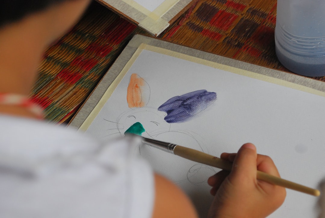 person holding white and brown pen