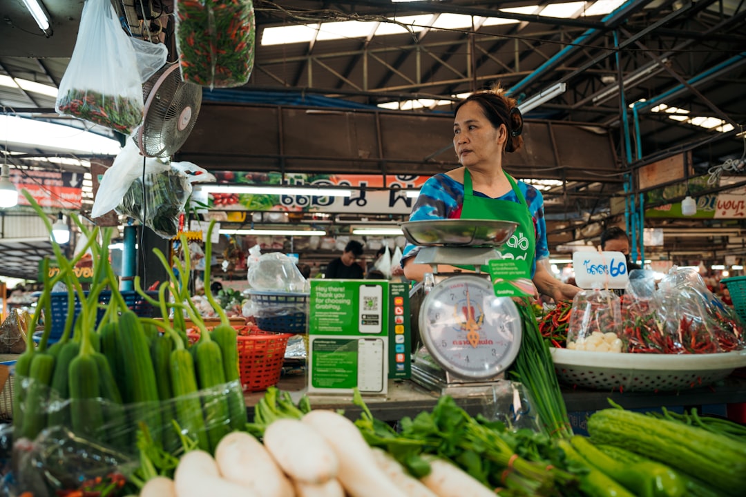 a woman standing in front of a display of vegetables