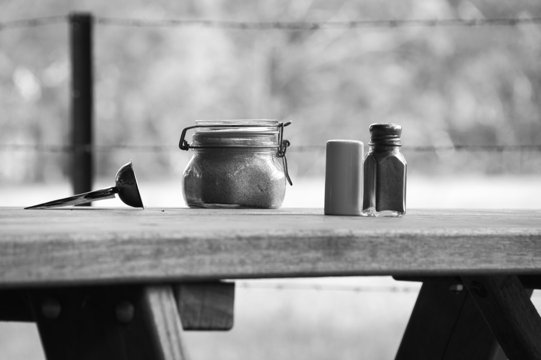 Three containers on a wooden picnic table.
