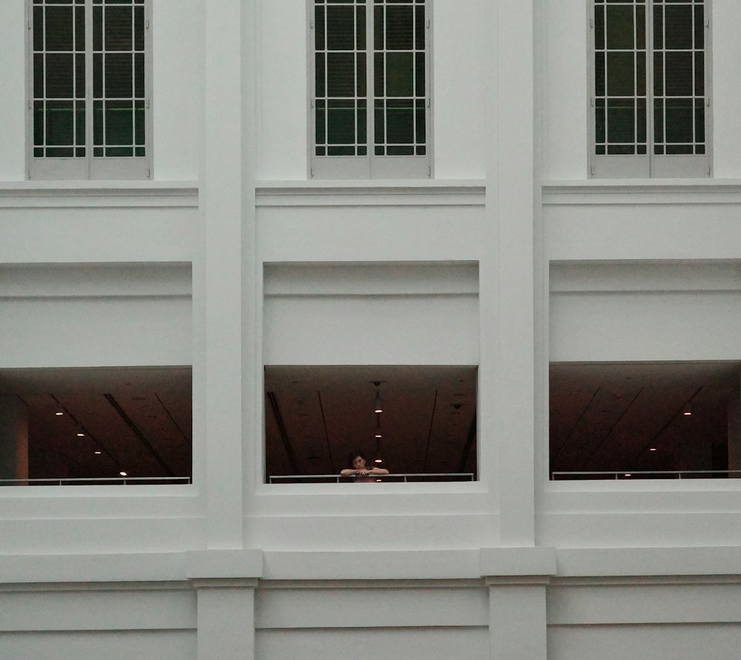 A white building with three windows and a clock