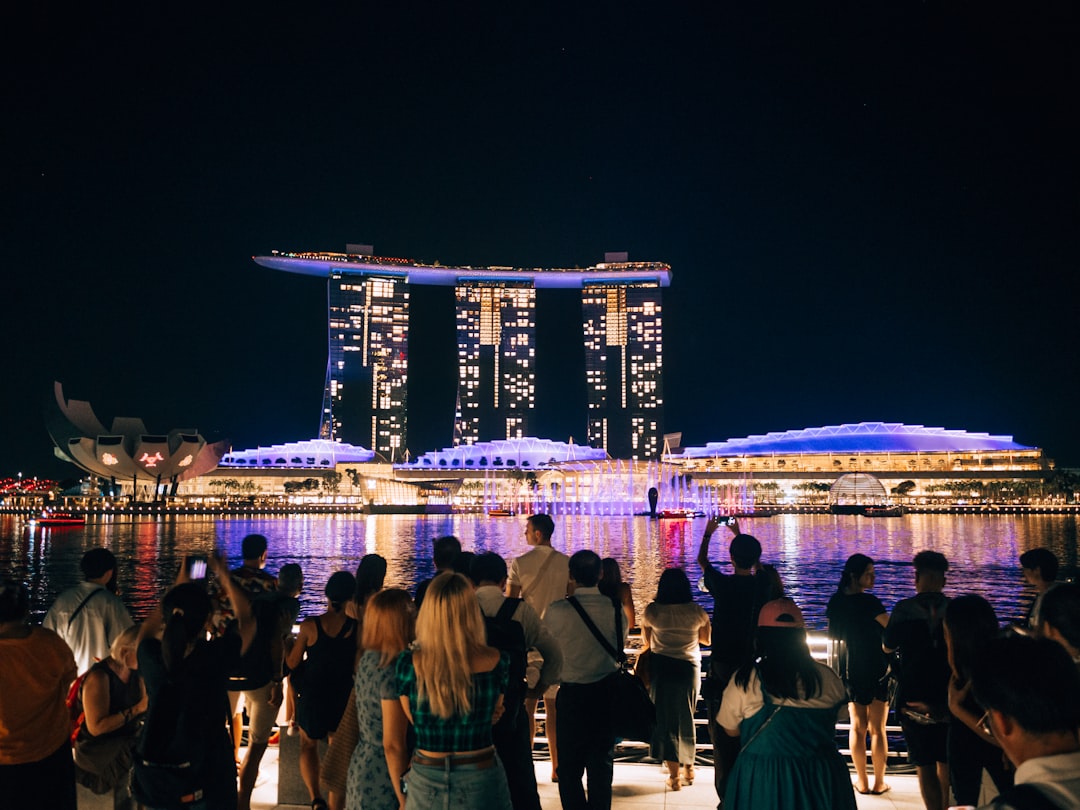 People watch illuminated marina bay sands at night