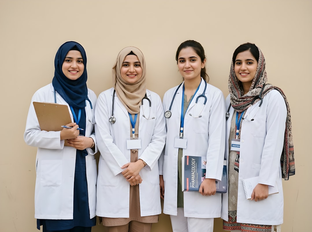 Four smiling female doctors in white coats