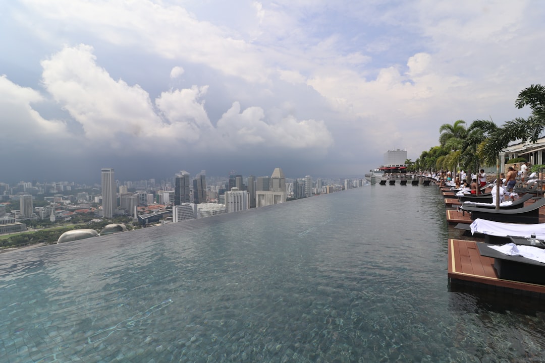 Infinity pool overlooking a cityscape under cloudy skies