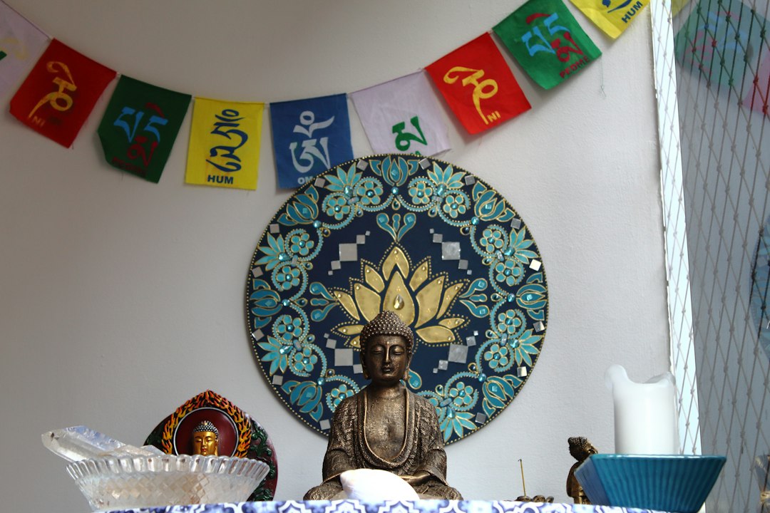 Buddha statue with prayer flags and lotus mandala