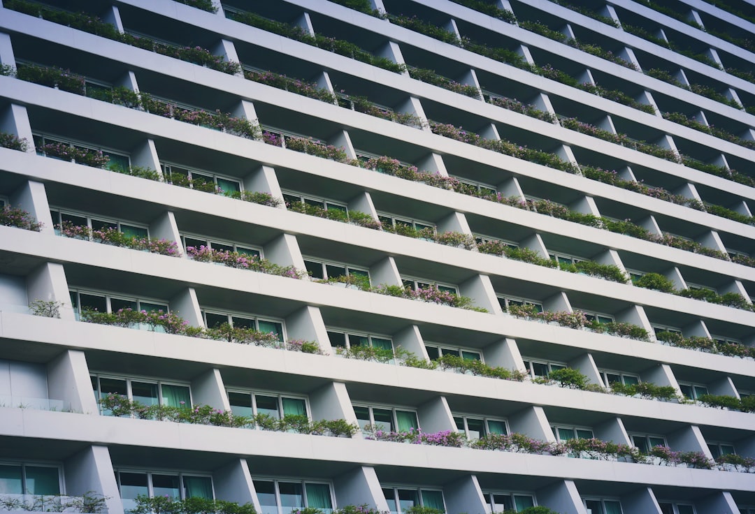 low-angle photography of white building with garden terrace