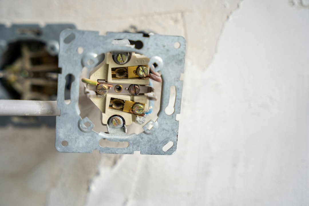 Electrical outlet disassembled, revealing the wiring