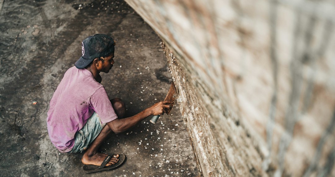 a man sitting on the ground working on something