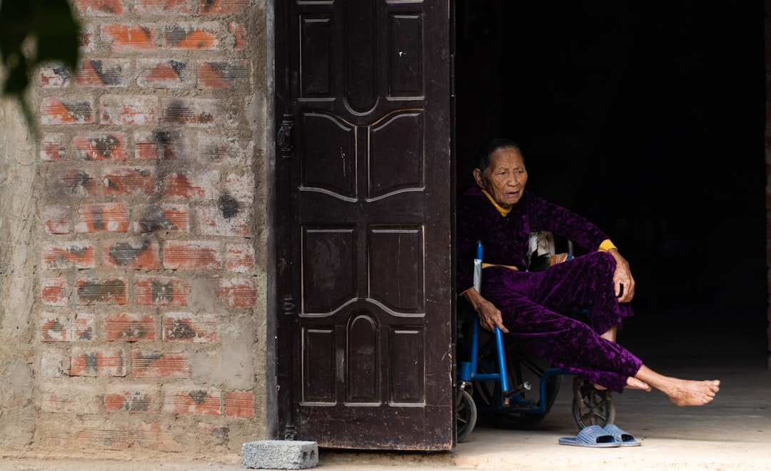 woman in purple robe sitting on blue chair near brown wooden door