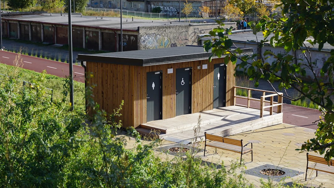 Wooden public restroom building with three doors.
