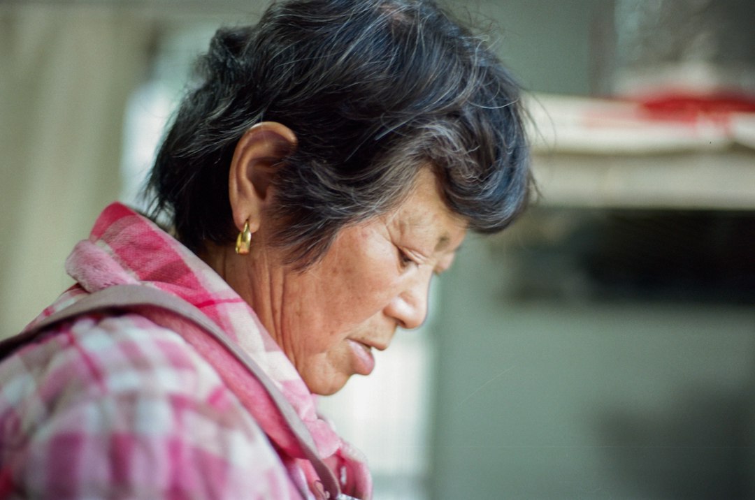 A woman is looking down at her cell phone