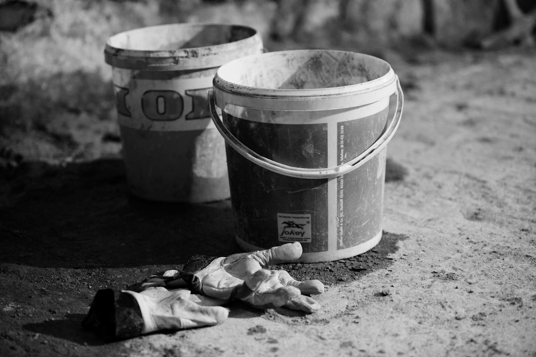 a couple of buckets sitting on top of a dirt road