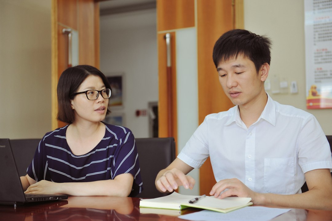 Two colleagues discussing work at a table