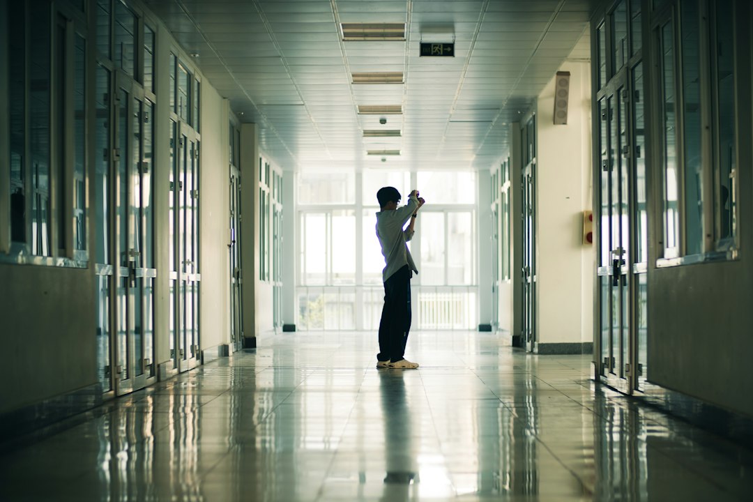 A person stands in a long, empty hallway