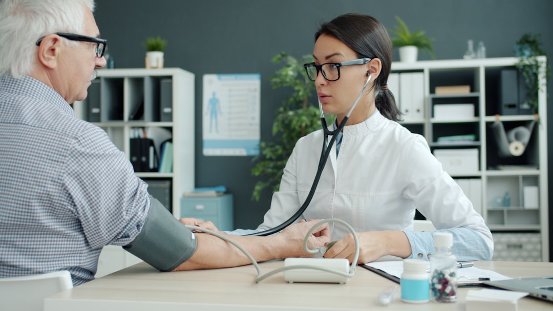 Doctor takes elderly patient's blood pressure