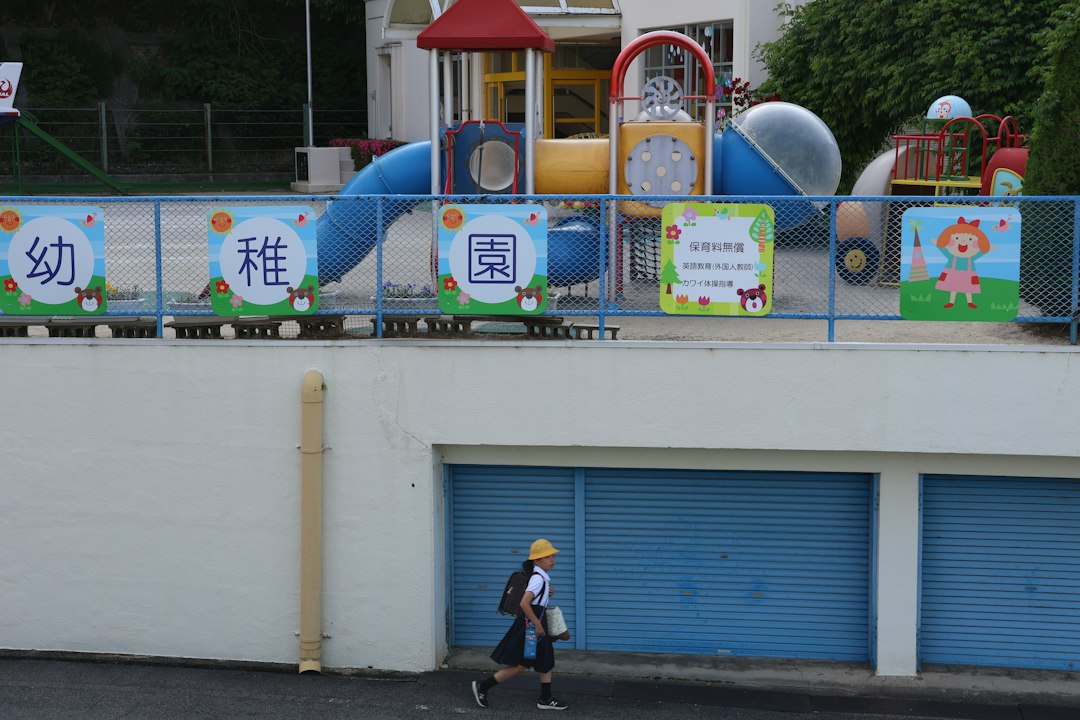 A child runs past a playground and school