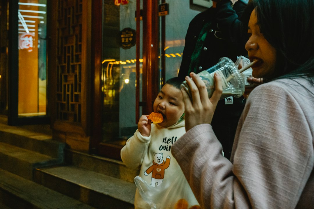 a woman and a child eating food outside of a building