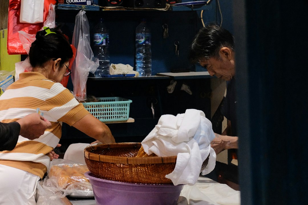 A man and a woman working on a basket
