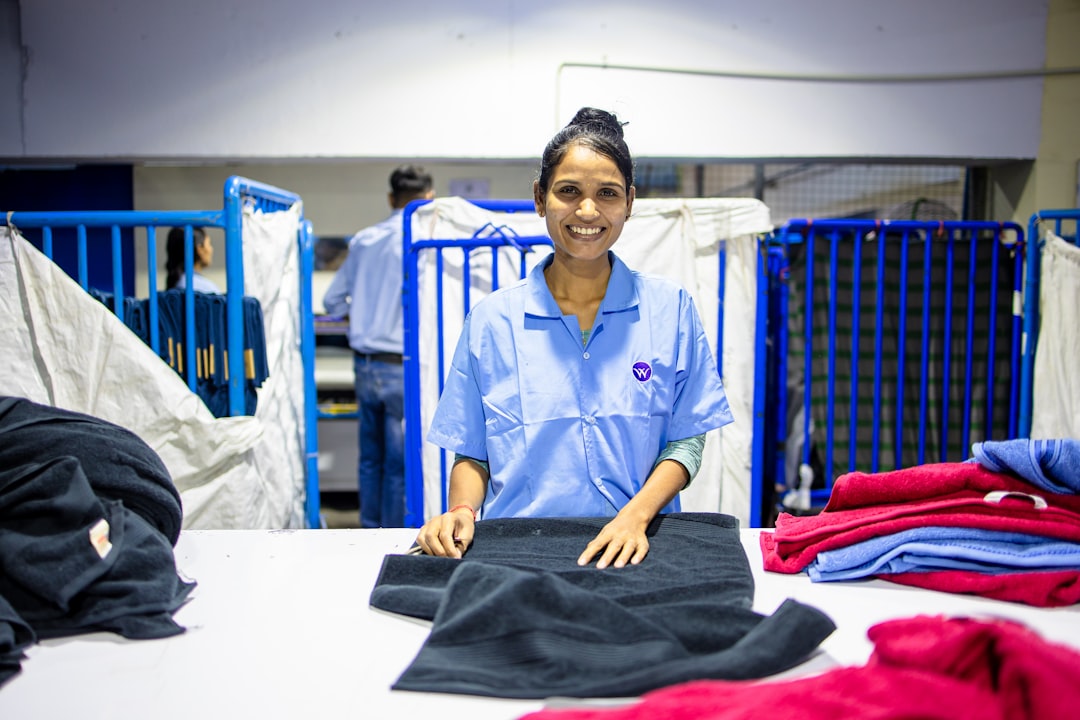 Woman folding laundry and smiling at the camera.