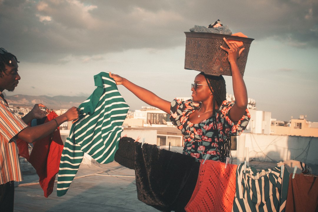 Two women hanging laundry on a rooftop
