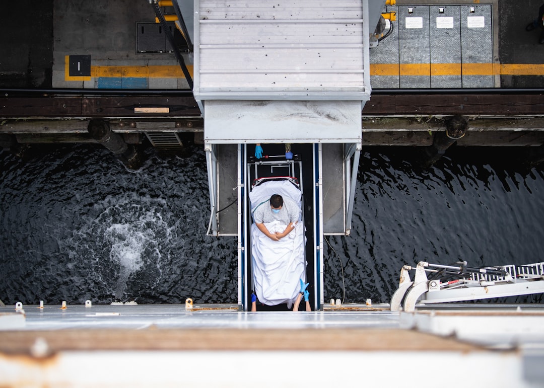 A person in a stretcher being lowered into water.