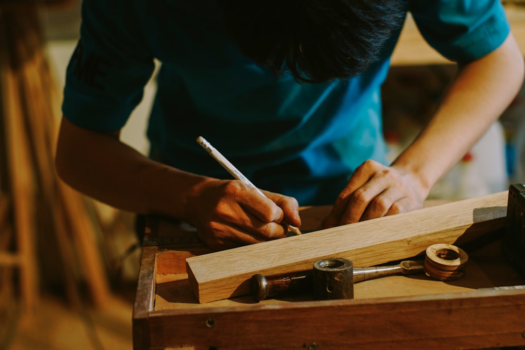 Person marking wood with a pencil