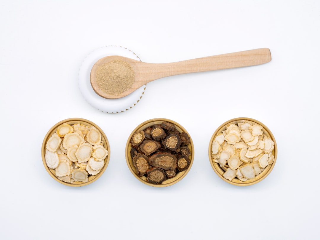 three bowls of cereal and a spoon on a white surface