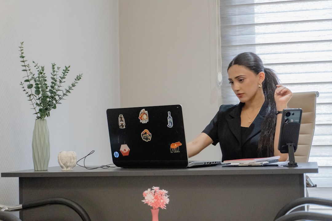 Woman working on a laptop at a desk.