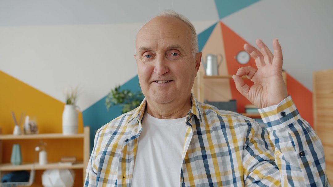 Elderly man gives an okay sign with his hand.