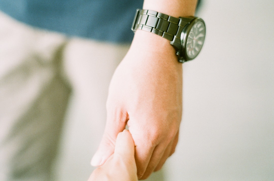 person wearing silver round analog watch
