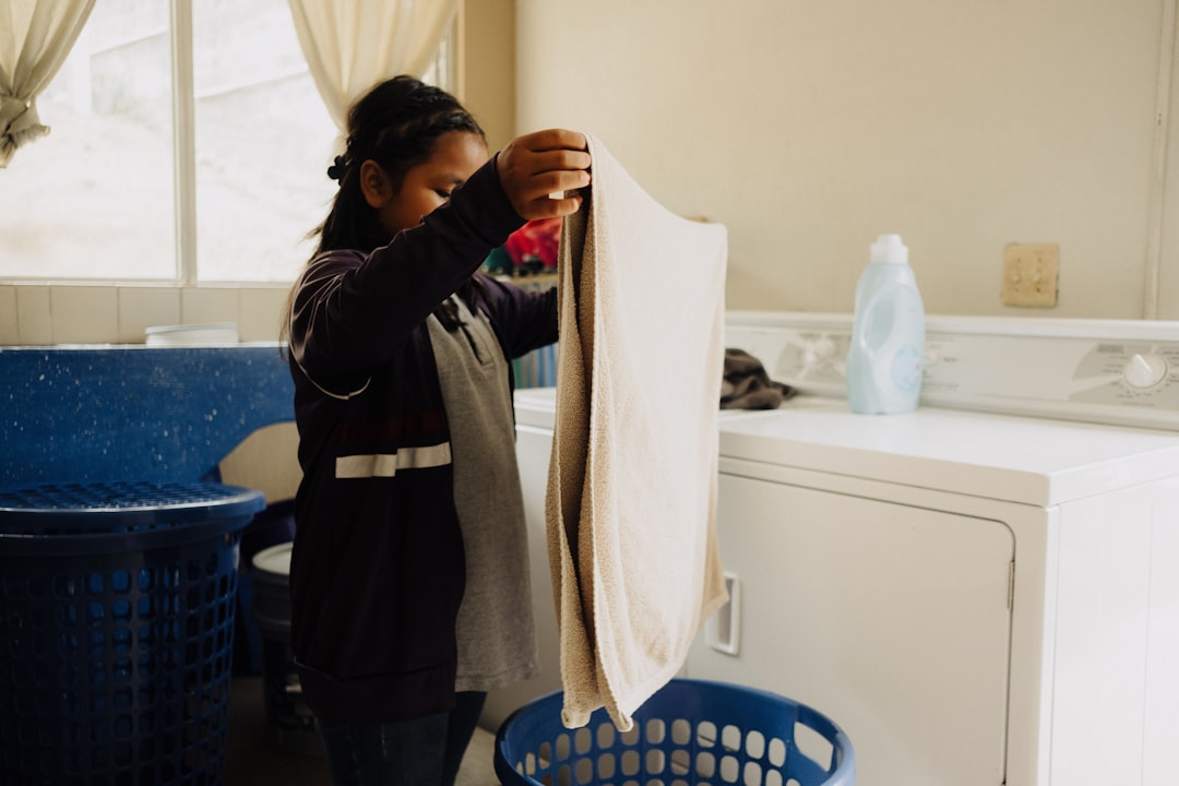 A woman standing in a kitchen next to a washing machine