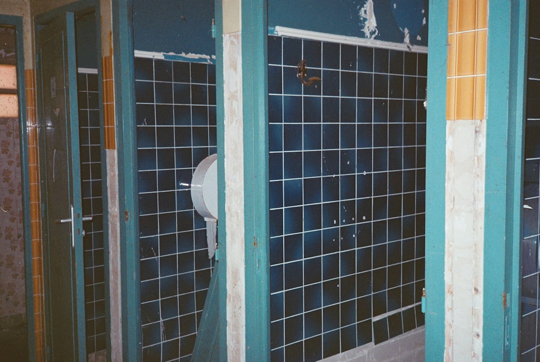 a bathroom with blue tiled walls and a white toilet