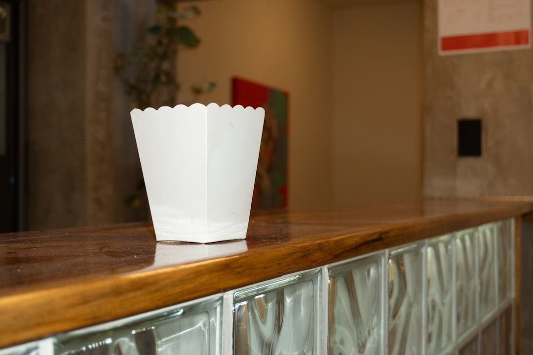 A white popcorn box on a wooden counter.