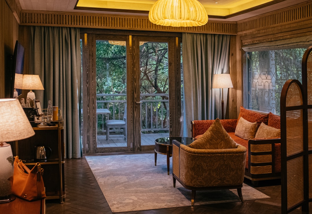 Luxurious hotel room with balcony overlooking trees.