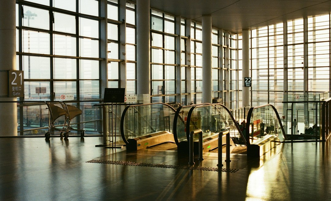 Modern airport interior with escalators and large windows