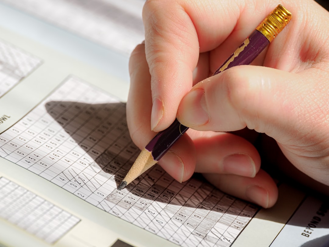 A person holding a pencil and writing on a piece of paper