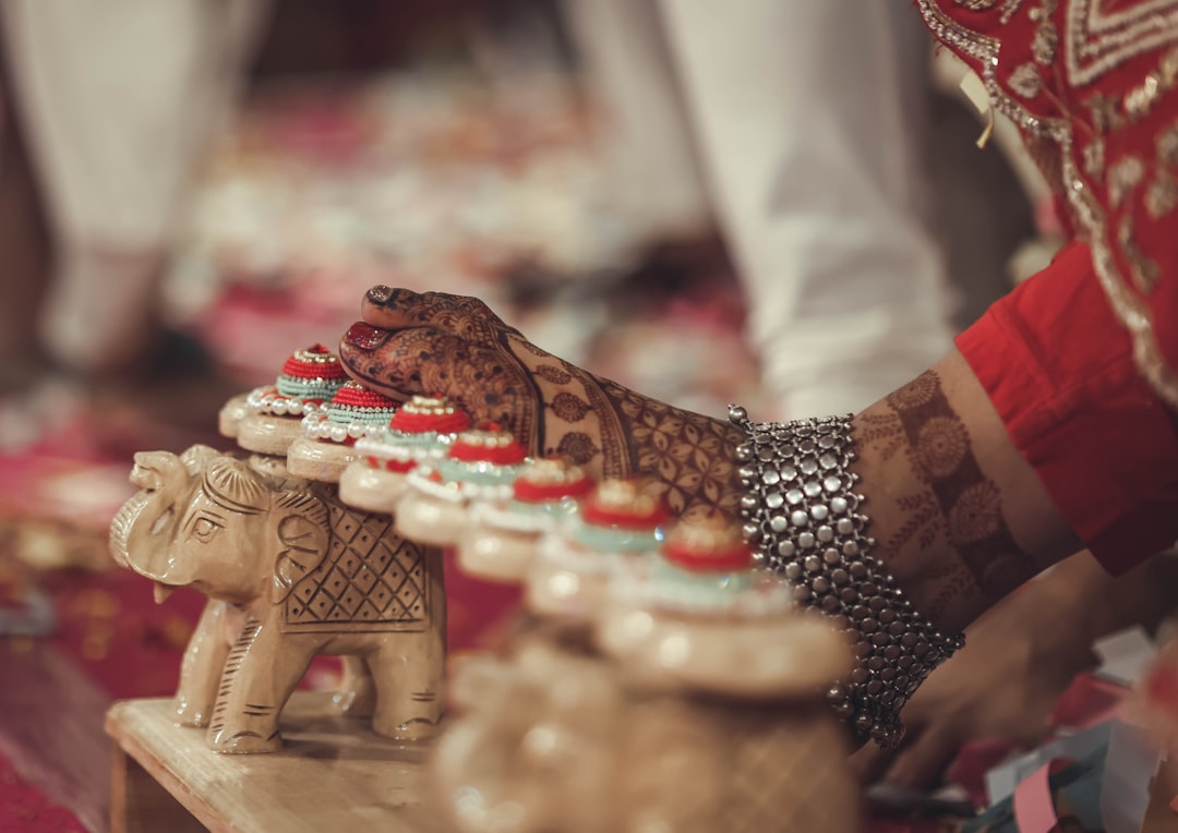 A close up of a person touching a small elephant figurine