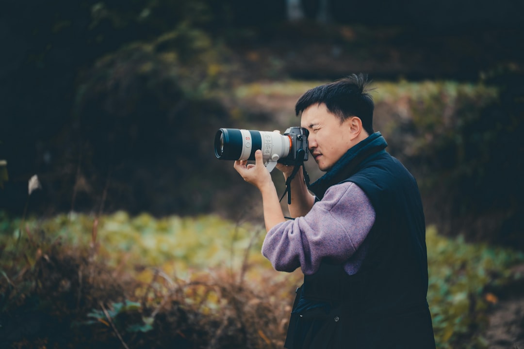 Man with professional camera taking a photo outdoors shot outdoors
