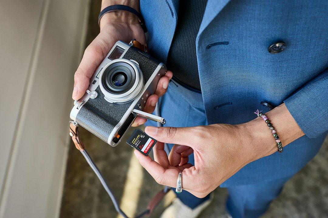 Hands inserting an sd card into a retro camera